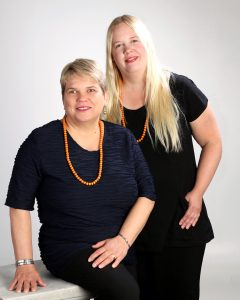 Kaksi vaaleahiuksista naista mustissa vaatteissa