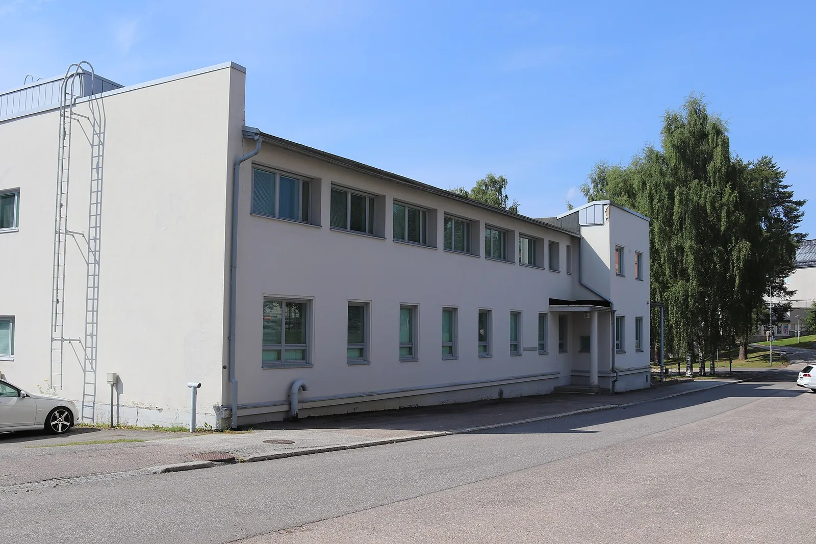 Sairaalan valkoinen rakennus kadun varrella