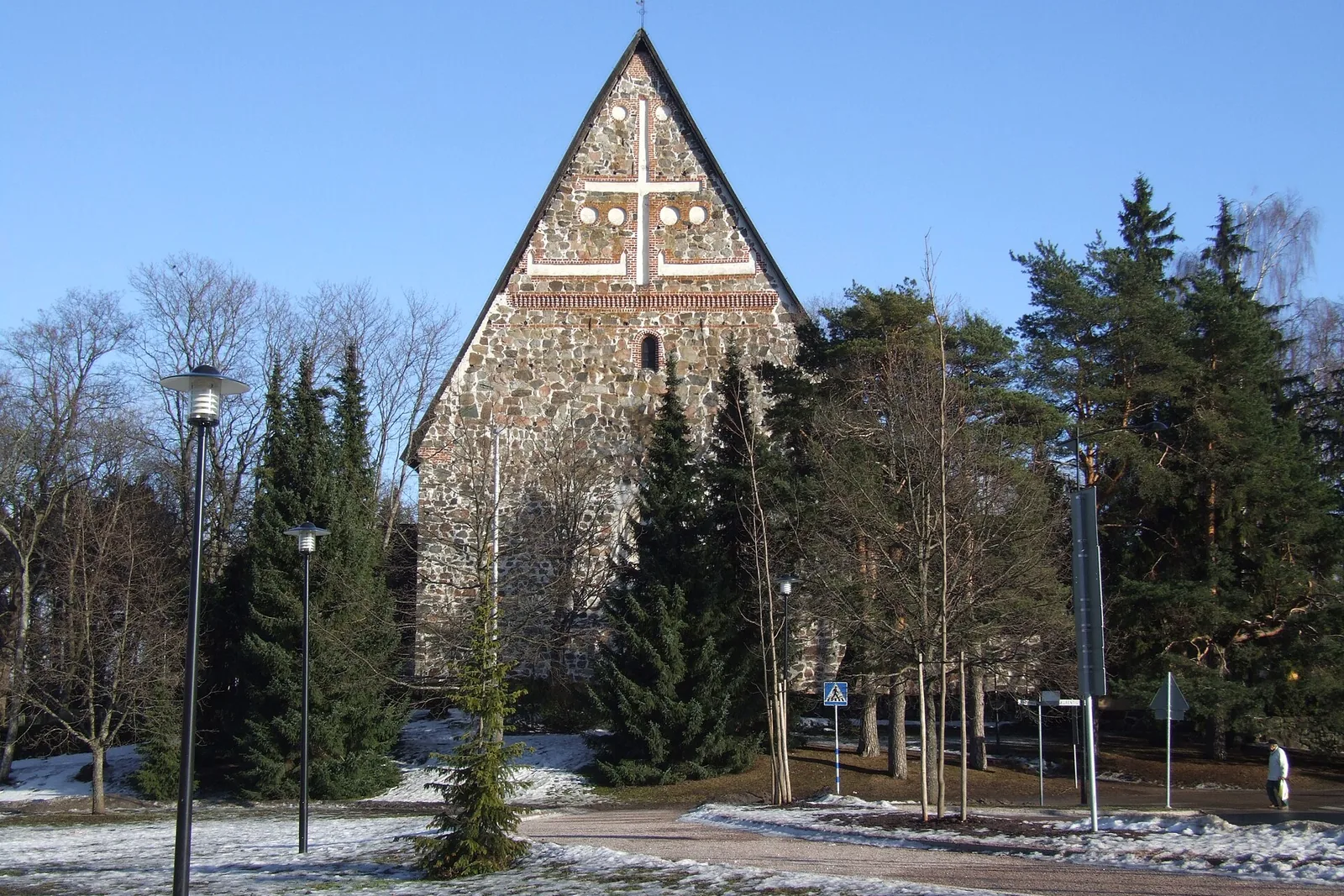 Keskiaikainen kivikirkko ja sen päätyjulkisivu kirkkaana päivänä