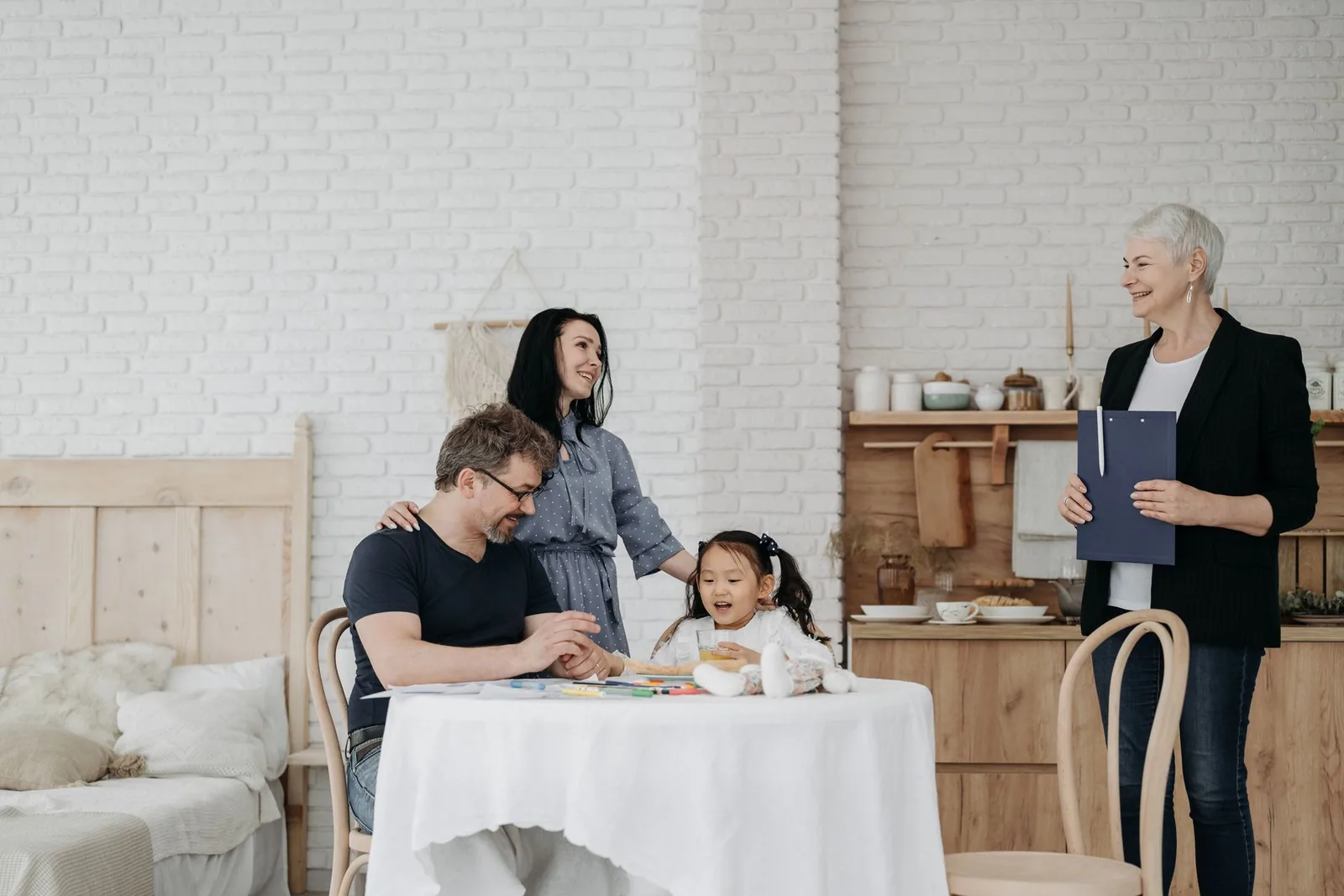 Perhetyöntekijä ja vanhemmat lapsen kanssa pöydän ääressä