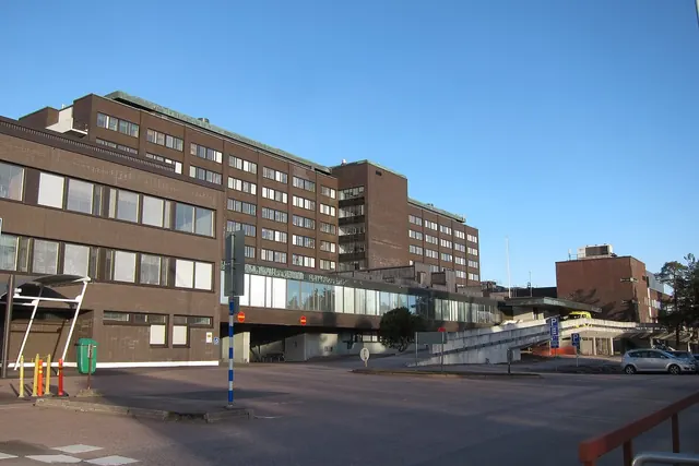 Suuri sairaalarakennus ja sen sisäänkäynti selkeää taivasta vasten