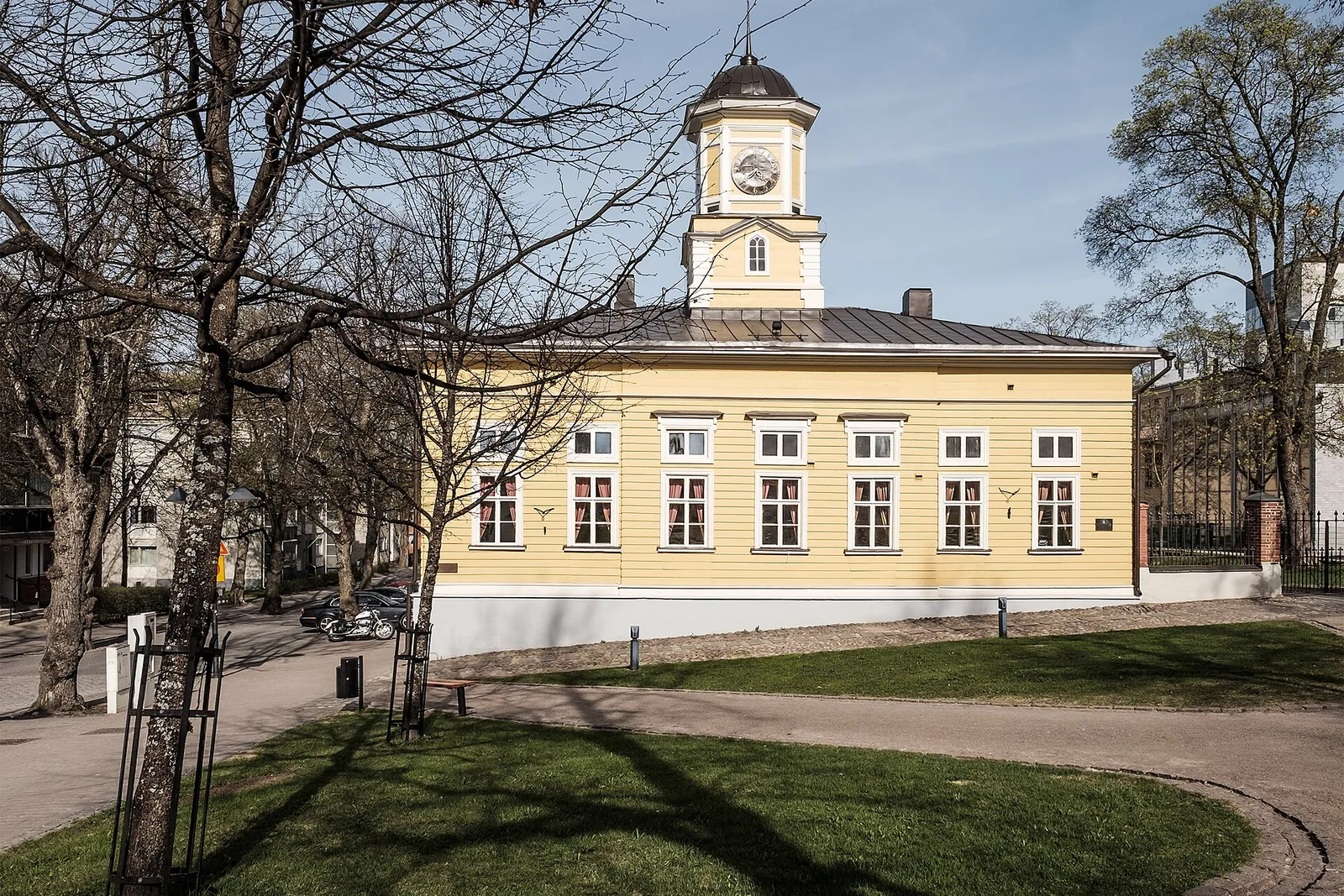 Keltainen kaupungintalo kellotorneineen puiston vieressä