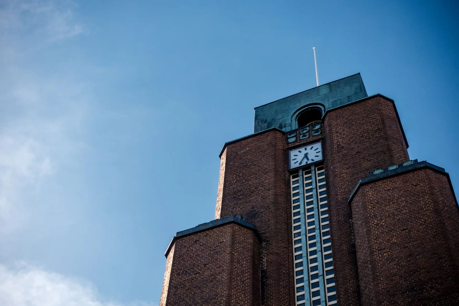 Punatiilinen kirkontorni kellotauluineen sinistä taivasta vasten